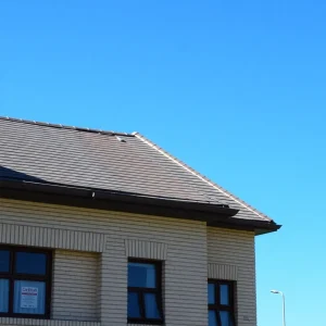 School building with repaired roof under clear blue sky.