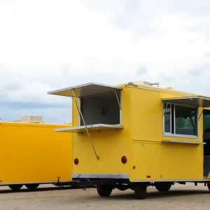 Empty food trucks parked under a cloudy sky.